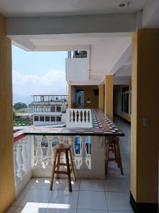 a balcony with a table and stools on a building at CASA EMILY in San Pedro La Laguna