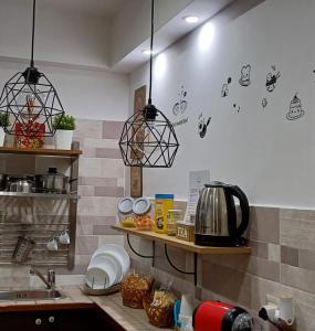 une cuisine avec deux lampes suspendues sur un plan de travail dans l'établissement Casa Bella mbriana, à Naples