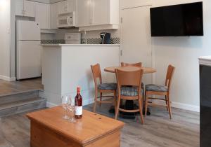 eine Küche mit einem Tisch und Stühlen sowie einer Flasche Wein in der Unterkunft Alpenglow Lodge Family Studio with Murphy Bed by MVA in Whistler