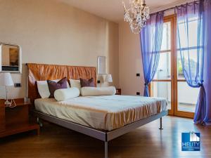 1 dormitorio con 1 cama grande con cortinas azules y lámpara de araña en [Blissful Haven]Luxurious VILLA with POOL* * * * *, en San Ruffillo