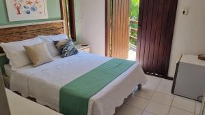 1 dormitorio con cama y ventana grande en Pousada Peixe Espada en Praia do Forte