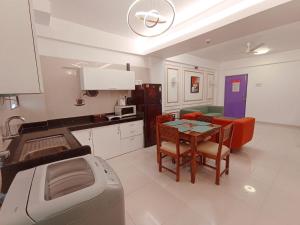 cocina y sala de estar con mesa y fogones en Most convenient 2 BR apartment in central Anjuna, en Anjuna