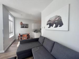 a living room with a couch and a picture of a bear at Alpenglow Lodge West Coast Wonder by MVA in Whistler