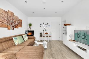 ein Wohnzimmer mit einem Sofa und einem Tisch in der Unterkunft Ferienwohnung Blickfang am Nordberg in Goslar