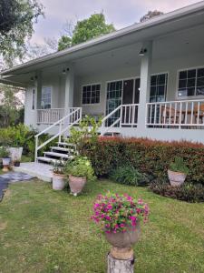 una casa blanca con flores delante en Brook Villa Khaoyai en Pak Chong