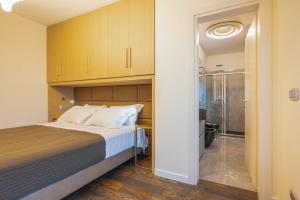 1 dormitorio con 1 cama y puerta corredera de cristal en Venice New Luxury Penthouse - free parking and roof terrace, en Mestre