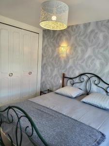 1 dormitorio con cama y lámpara de araña en Gîte Cadet rousselle, en Lessay