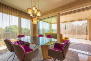 a dining room with a glass table and purple chairs at Venice New Luxury Penthouse with parking in Mestre