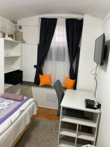 a small room with a bed and a desk and a window at Centrum Wellness Hostel in Debrecen