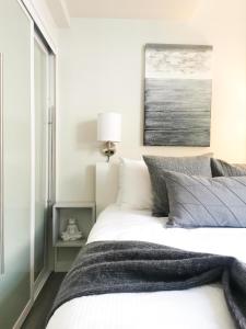 a bedroom with a large white bed and a window at Alpenglow Lodge HYGGE Getaway by MVA in Whistler