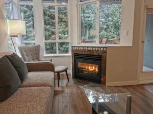 a living room with a couch and a fireplace at Alpenglow Lodge HYGGE Getaway by MVA in Whistler