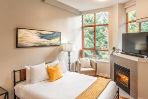 um quarto com uma cama com lareira e uma televisão em Alpenglow Lodge Large Studio by MVA em Whistler