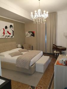 Un dormitorio con una cama grande y una lámpara de araña. en Varazze Suite Sauna e Hammam, en Varazze