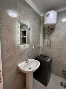 a bathroom with a sink and a mirror and a trash can at Madinaty, Elite new apartment with garden in Madinaty