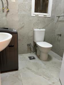 a bathroom with a toilet and a sink at Madinaty, Elite new apartment with garden in Madinaty