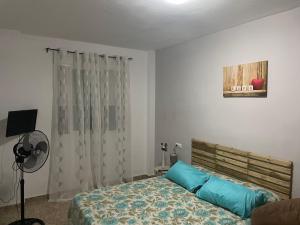 ein Schlafzimmer mit einem Bett mit blauen Kissen in der Unterkunft Edificio La Horteta in La Font D´En Carròs