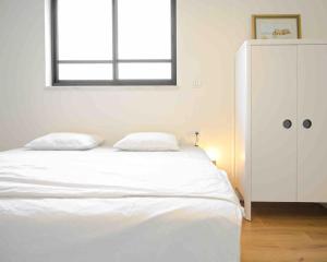 1 cama blanca en un dormitorio con ventana en Hula Valley Scenery New App, en Gonen
