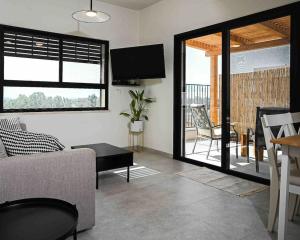 sala de estar con sofá y TV en Hula Valley Scenery New App, en Gonen