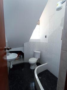 a bathroom with a toilet and a sink and a tub at Amplio departamento en Cajamarca in Cajamarca