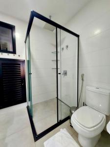 a bathroom with a toilet and a glass shower at Uma Linda Vista com Quarto Privativo no Ed. Vertigo in Campo Grande +9 photos