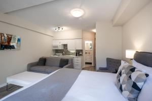 ein Schlafzimmer mit einem Bett und ein Wohnzimmer in der Unterkunft Alpenglow Lodge Sunny Studio with Sitting Area by MVA in Whistler