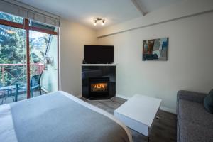 ein Schlafzimmer mit einem Bett und einem Kamin in der Unterkunft Alpenglow Lodge Sunny Studio with Sitting Area by MVA in Whistler
