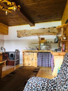 a kitchen with wooden ceilings and a kitchen with a couch at Stara chałpa oźna in Sól