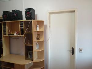 a room with a book shelf with cameras on it at Alugo quarto, próximo à praia in Torres