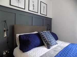 a bedroom with a bed with blue pillows on it at 2 Bedroom Luxury City Centre Apt in Lincoln