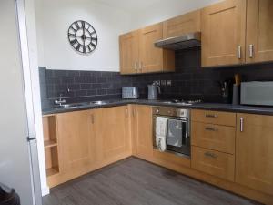 a kitchen with wooden cabinets and a stove at 2 Bedroom Luxury City Centre Apt in Lincoln