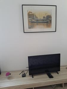 Une télévision à écran plat est installée au-dessus d'une table en bois. dans l'établissement Dubbelink 3A, à Amsterdam
