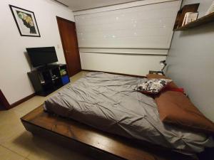 a bedroom with a bed and a flat screen tv at Apartamento-suite en la mejor zona de Guayaquil in Guayaquil