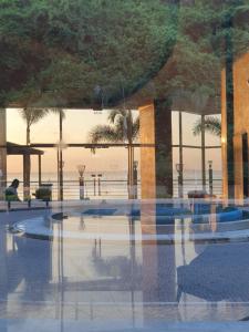 a reflection of a building with palm trees in the foreground at Apartamento-suite en la mejor zona de Guayaquil in Guayaquil