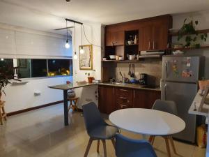 uma cozinha com uma mesa, uma mesa e um frigorífico em Apartamento-suite en la mejor zona de Guayaquil em Guayaquil