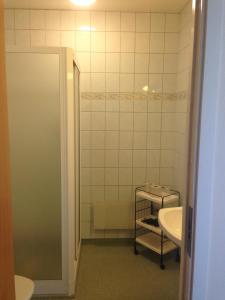 ein Badezimmer mit einem Waschbecken, einem WC und einem Spiegel in der Unterkunft Kils Hotell & Restaurang in Kil