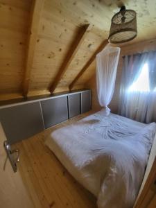 Ilijaš的住宿－Vikendica Chalet Nišići，木制客房内的一间卧室,配有一张床