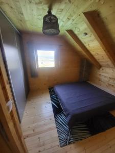 a tiny house with a bed in the attic at Vikendica Chalet Nišići in Ilijaš