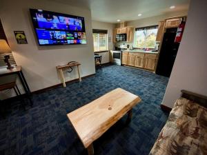 un salon avec une table et une télévision murale dans l'établissement Bear Mountain - Suite 7, à Grants Pass