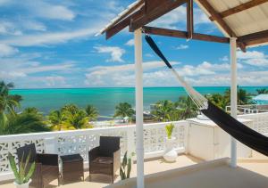 un balcón con hamaca y vistas al océano en Treetops Hotel en Caye Caulker