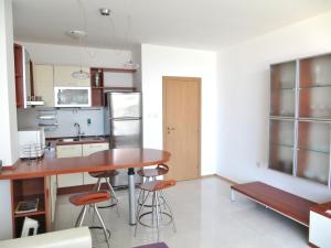 kuchnia z drewnianym stołem i stołkami w obiekcie Holiday Apartment in Riviera Complex w Swetim Własie