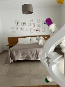 a bedroom with a bed and pictures on the wall at LE RONDINI HOUSE in Monopoli