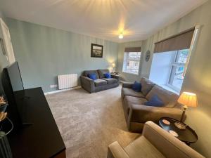 a living room with couches and a couch and a table at 16 Macgregor court, Oban in Oban