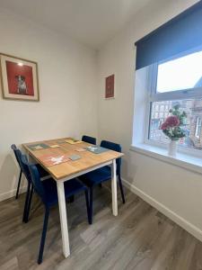 a table and chairs in a room with a window at 16 Macgregor court, Oban in Oban