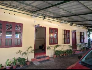 a house with red doors and potted plants on it at Cicily Holidays Inn in Munnar