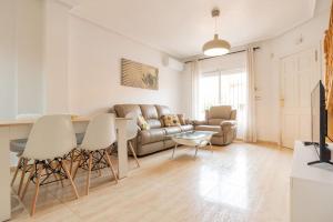 ein Wohnzimmer mit Sofa und Tisch in der Unterkunft Villa Mariposa in Orihuela