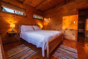 a bedroom with a bed in a log cabin at Cabañas Bosques de Puertecillo in Puertecillo
