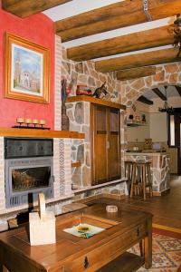 sala de estar con chimenea de piedra y mesa en Casa Rural Cristina III, en San Pablo de los Montes