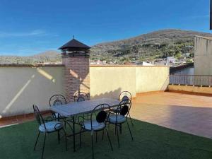 una mesa y sillas en un patio con vistas en Casa Rural Cristina III, en San Pablo de los Montes