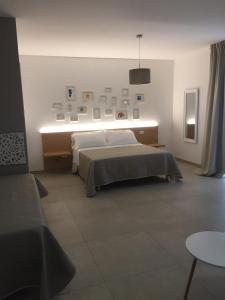 um quarto com uma cama com uma luz na parede em LE RONDINI HOUSE em Monopoli