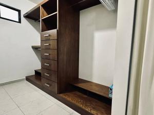 a closet with wooden drawers and a mirror at Departamento Longoria 4A in Matamoros